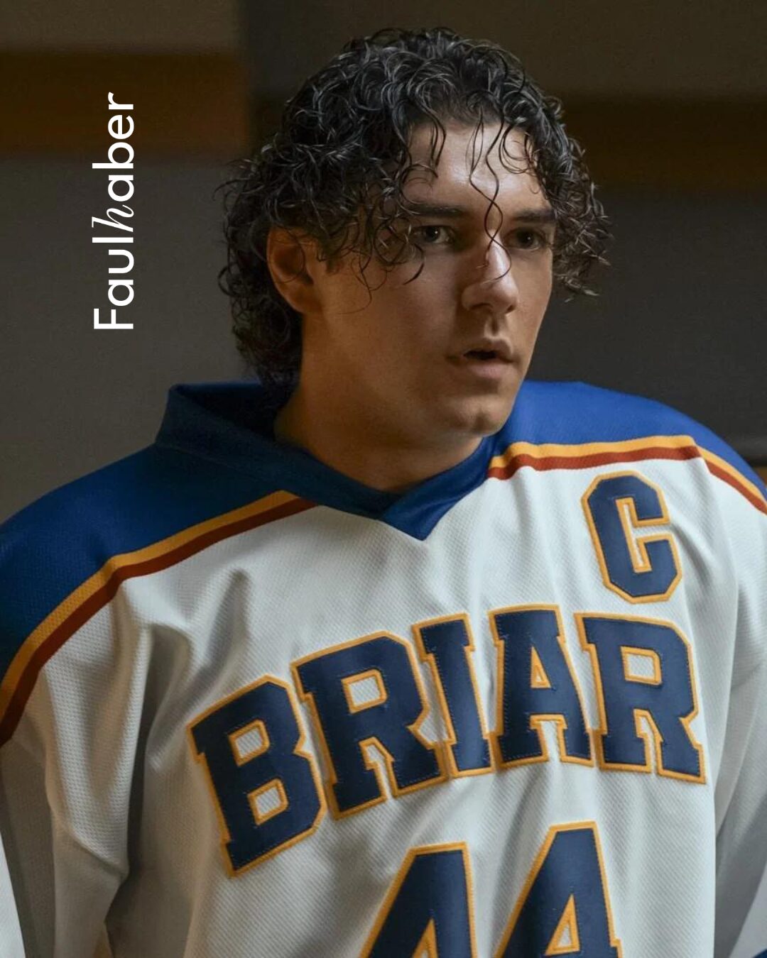 Portrait of a young hockey player with curly hair wearing a blue-and-white Bruins jersey with number 44 and a captain patch.
